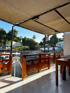Houseboat Hotel and Nile Cruises Zainoba في Nag` el-Ramla: قارب مع طاولة وإطلالة على الماء
