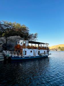 a white boat is docked in the water at Houseboat Hotel and Nile Cruises Zainoba in Nag` el-Ramla