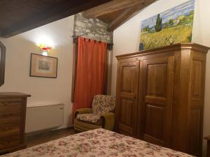 1 dormitorio con 1 cama y 1 silla en Casa dell'uliveto, en Albettone