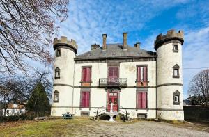 an old castle with red shutters on top of it at Le Château Giat in Giat