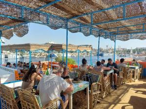 a group of people sitting at tables on a boat at Bob Marley Guest House in Aswan