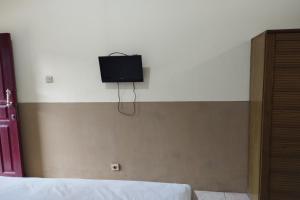 - une télévision sur le mur d'une chambre dans l'établissement OYO 93657 Puri Batu Bolong, à Senggigi