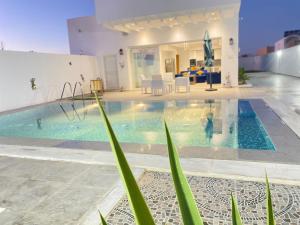 a swimming pool in a house with a person in the water at Dar Lili Djerba in Mezraya