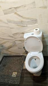 a bathroom with a toilet with a roll of toilet paper at Royal Crown Hotel عائلات فقط in Alexandria