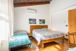 2 Betten in einem Zimmer mit weißen Wänden und Holzböden in der Unterkunft Fattoria Il Laghetto in Lamezia Terme