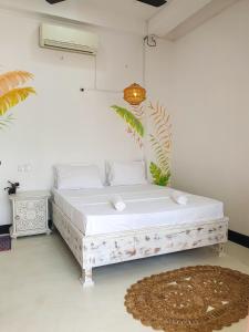 - un lit blanc dans une chambre avec un tapis dans l'établissement GypSea Madiha, à Madihe East
