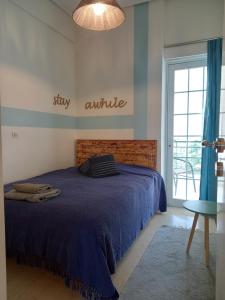 een slaapkamer met een bed met een blauw dekbed bij Evie's apartment in Kalamata