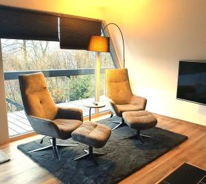 Duas cadeiras e uma mesa num quarto com uma janela em Bigge Huus Ferienhaus em Olpe