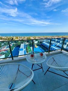 a balcony with two tables and a view of the ocean at Amazing seaview studio with pool-steps away beach in Áyios Yeórgios