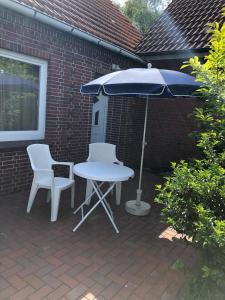 a table and two chairs and an umbrella on a patio at Ferienwohnung Nordmoor in Blomberg