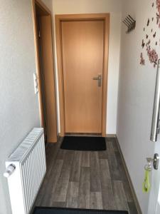 a hallway with a brown door and a floor at Ferienwohnung Nordmoor in Blomberg