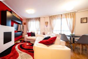 sala de estar con sofá blanco y almohadas rojas en Casa Nerai Apartamento, en Gijón