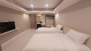 Habitación de hotel con 2 camas y TV de pantalla plana. en PKK hotel Residence en Bang Phli