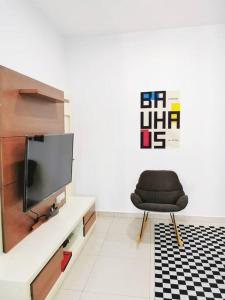 a black chair in a room with a tv at IPOH BOTANI bauhaus 17pax/4BR/mahjong/tv box in Ipoh