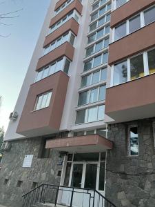 a tall apartment building with a stone facade at Апартамент Рая in Devin