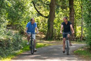 dos hombres montando bicicletas por un camino de tierra en Camping maeva Respire La Serre, en Aigues-Vives