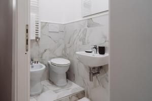 een witte badkamer met een toilet en een wastafel bij Rooms Genova dei Rolli in Genua
