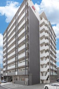 un immeuble d'appartements avec balcon dans un parking dans l'établissement FDS Plaisir, à Osaka