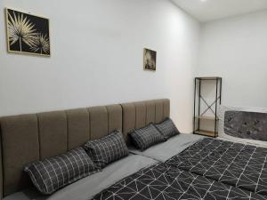 a bed with two pillows in a room at IPOH BOTANI bauhaus 17pax/4BR/mahjong/tv box in Ipoh