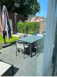 - une table, des chaises et un parasol sur la terrasse dans l'établissement Lou et Hans, à Aalst