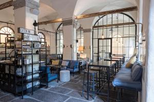 a store with tables and chairs in a room with windows at Alter Schlachthof in Bressanone