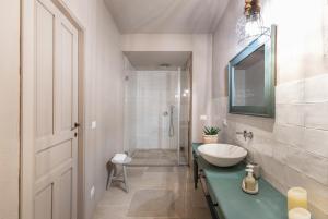 a white bathroom with a sink and a mirror at RoccaSeta in Scicli