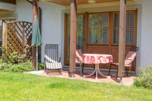 eine Terrasse mit 2 Stühlen, einem Tisch und einem Sonnenschirm in der Unterkunft Ferienhaus Behler in Kressbronn am Bodensee