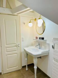 Baño blanco con lavabo y espejo en Villa Ker Elie-Yves à La Baule, en La Baule