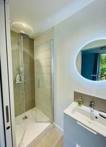 baño blanco con ducha y lavamanos en Villa Ker Elie-Yves à La Baule, en La Baule