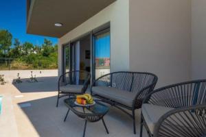 patio con sedie e un cesto di frutta su un tavolo di Villa Esmeralda One by Briskva a Novigrad Istria