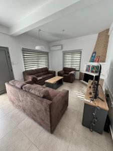 a living room with a large couch and a table at Villa Meropi in Paphos City