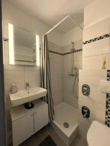 a white bathroom with a sink and a shower at Seesternchen in Heiligenhafen