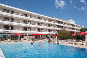 a hotel with a swimming pool with people in it at Hotel Arenal in San Antonio