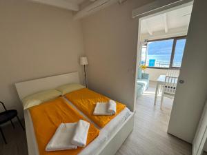 a bedroom with a bed with two towels on it at Lakeview Cannobio Camping & Resort in Cannobio