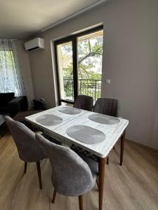 uma mesa de jantar com cadeiras e uma grande janela em 3 стаен апартамент идеален център Варна em Varna City