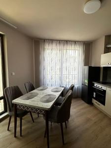 uma sala de jantar com mesa e cadeiras e uma cozinha em 3 стаен апартамент идеален център Варна em Varna City