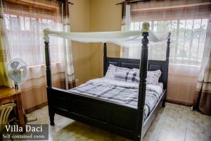 a bedroom with a black bed with a canopy at Villa Daci in Gulu