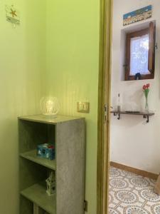 een kamer met groene muren, een plank en een raam bij Ta Maison Al Molo in Cefalù