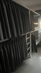 a wall of black curtains in a room at W District hostel in Bangkok