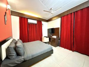 a bedroom with red curtains and a bed with a desk at entire house 17 rooms best for marriage/gatherings functions in Gurgaon