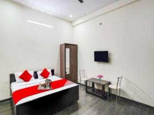 a room with a bed and a table and a tv at Heaven Stay in Greater Noida