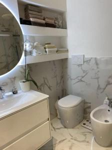 bagno con lavandino, servizi igienici e specchio di -Free Pool and Parking- Garda House Apartments a Castelnuovo del Garda