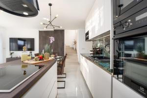 una cucina con mobili bianchi e un piano di lavoro di Villa Esmeralda Two by Briskva a Novigrad Istria