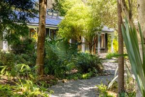 una casa con árboles y plantas delante de ella en The Ponds on Greenhill, en Waikanae