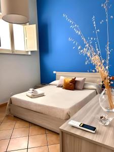ein Schlafzimmer mit einem Bett und einer blauen Wand in der Unterkunft Butera Apartments in Bagheria