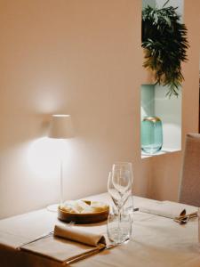un tavolo con un piatto di cibo e un bicchiere di vino di Cora Aparthotel Stradivari a CastellʼArquato