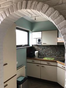 a kitchen with a stone archway in a kitchen at Apartment " KIISCHPELT " in Wilwerwiltz