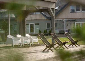 a group of lawn chairs sitting on a patio at Guest House Skrablas in Rucava