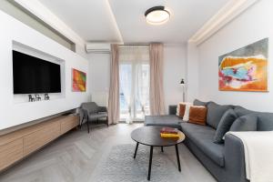 un soggiorno con divano blu e TV a schermo piatto di #Amazonia Apt by halu! Apartments a Salonicco