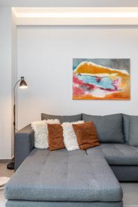 eine blaue Couch in einem Wohnzimmer mit einem Gemälde in der Unterkunft #Amazonia Apt by halu! Apartments in Thessaloniki